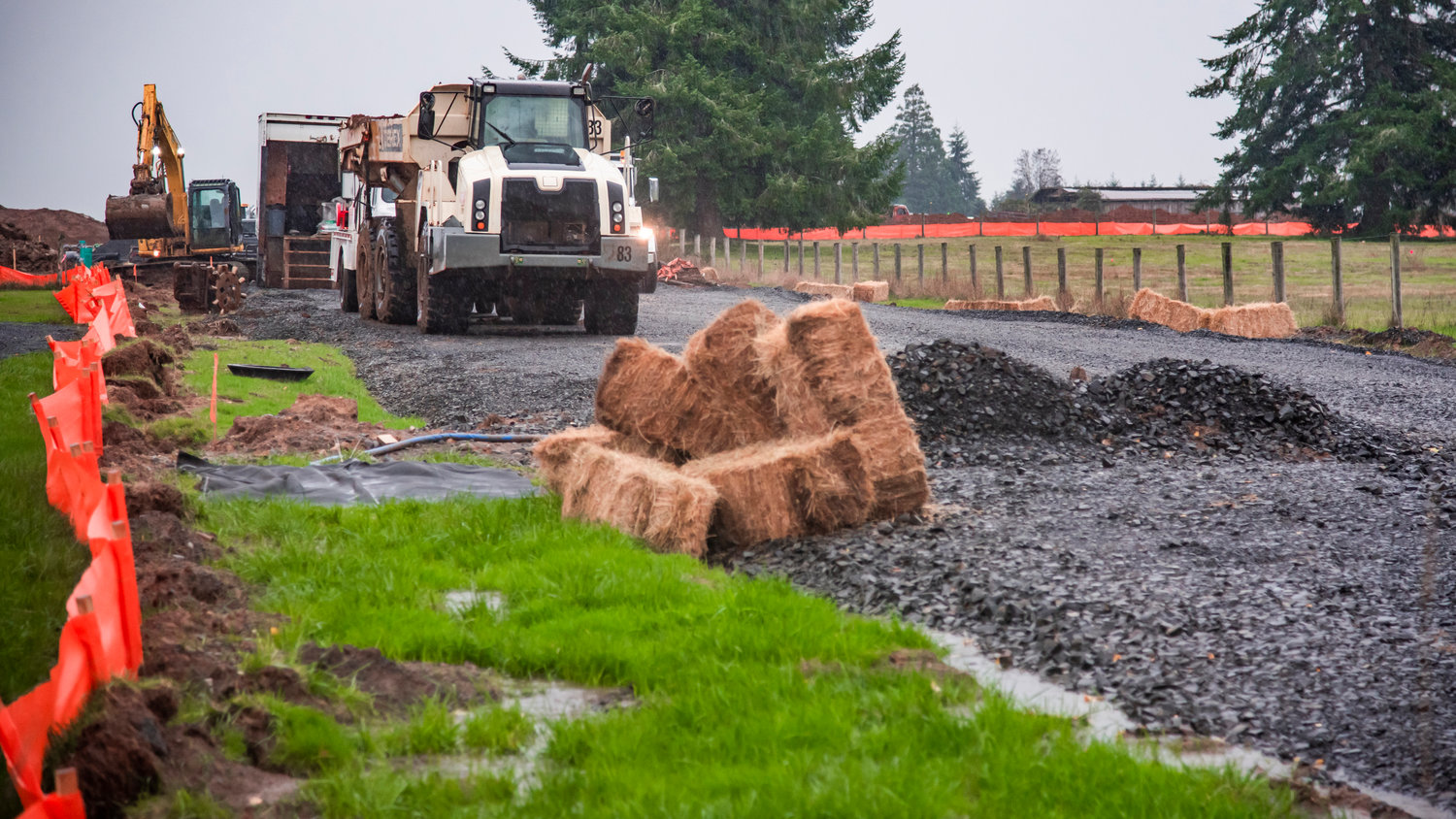 Bales of hay are used to mitigate water flow during a residential construction project in Winlock.